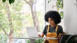 年轻快乐的非裔美国女人在她的笔记本电脑上